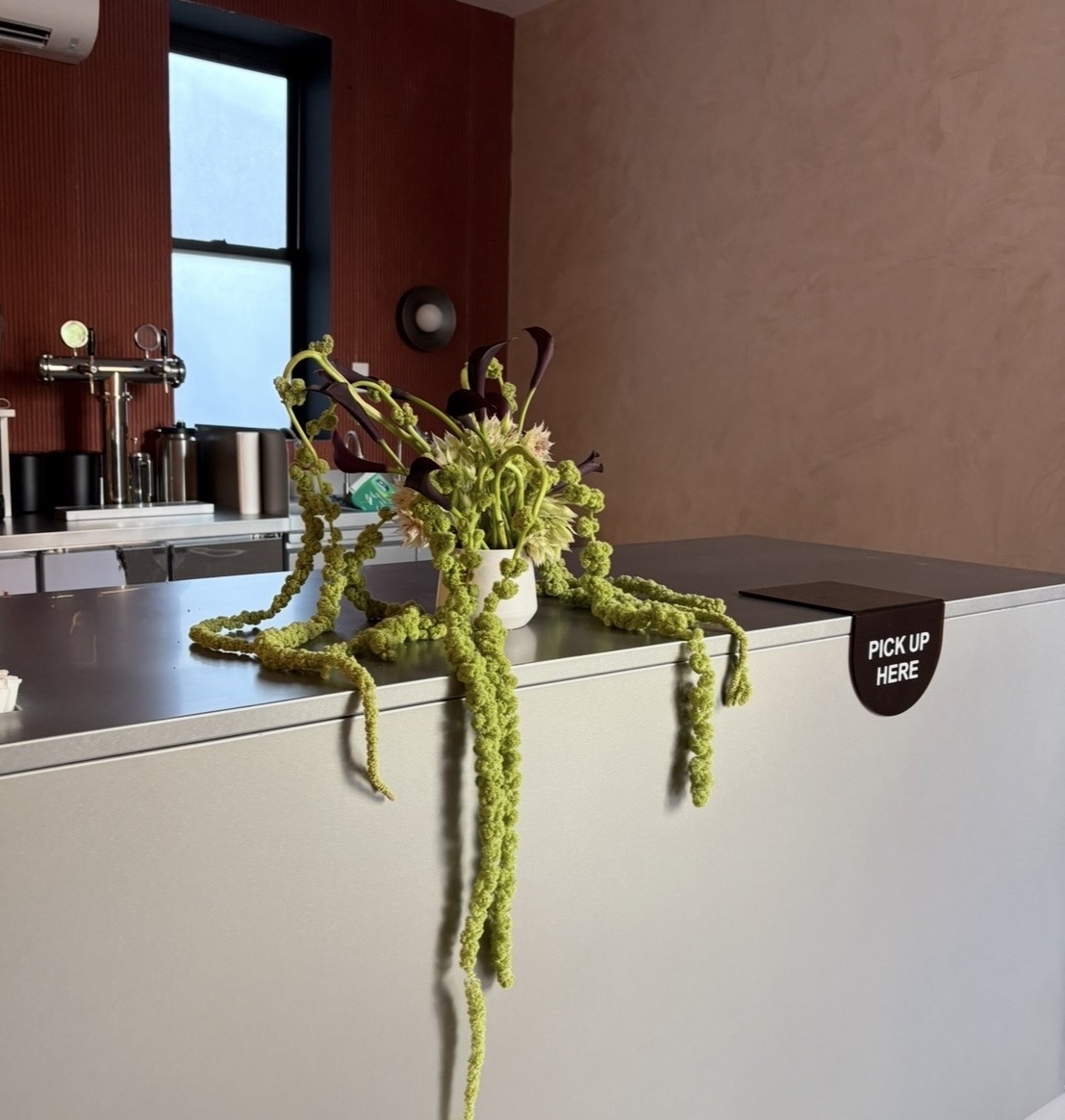 Trailing amaranth and dark calla lily brand activation arrangement for a coffee shop by Wilted NYC