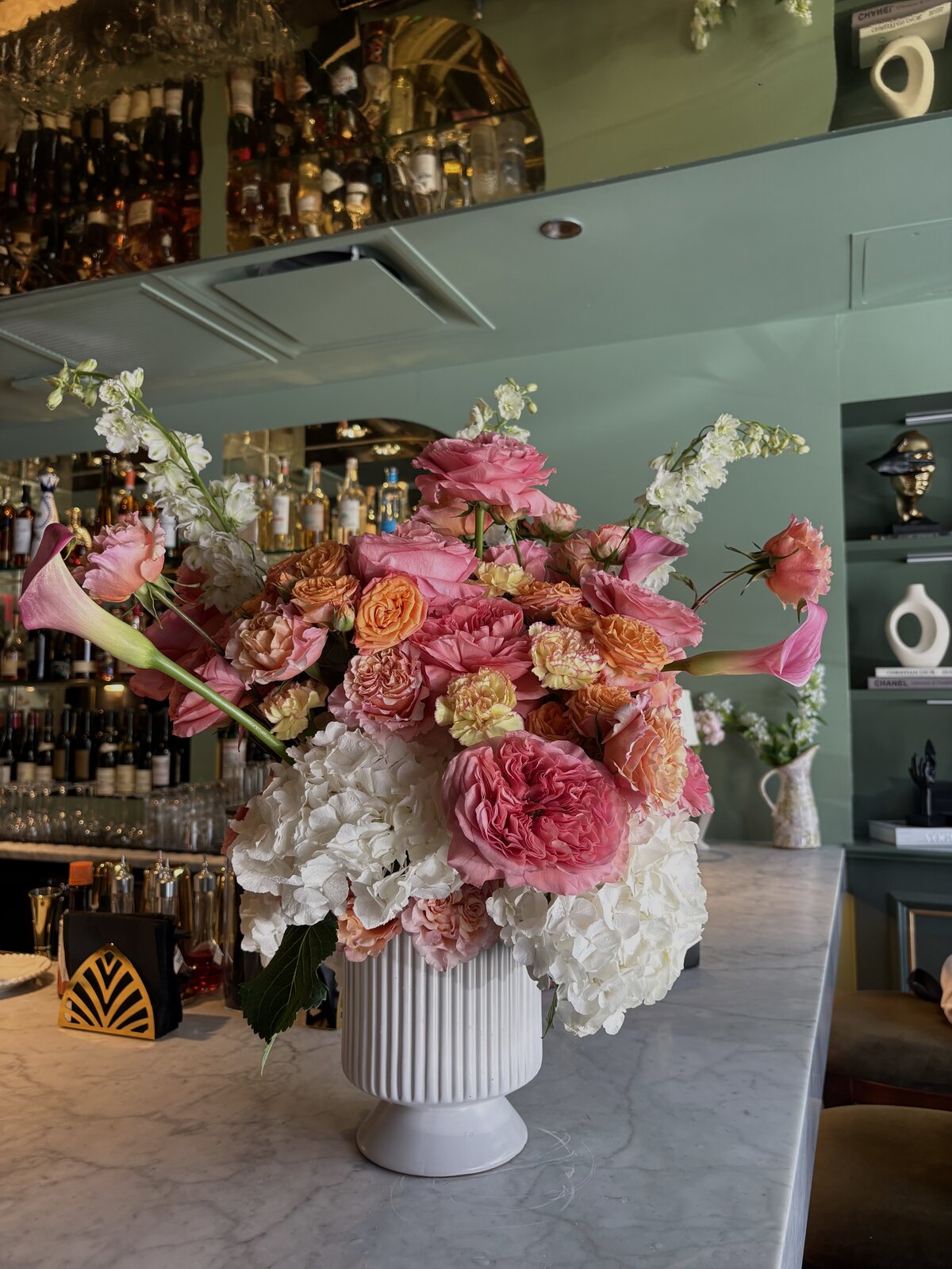 Hydrangea and garden rose arrangement styled on a restaurant bar by Wilted NYC
